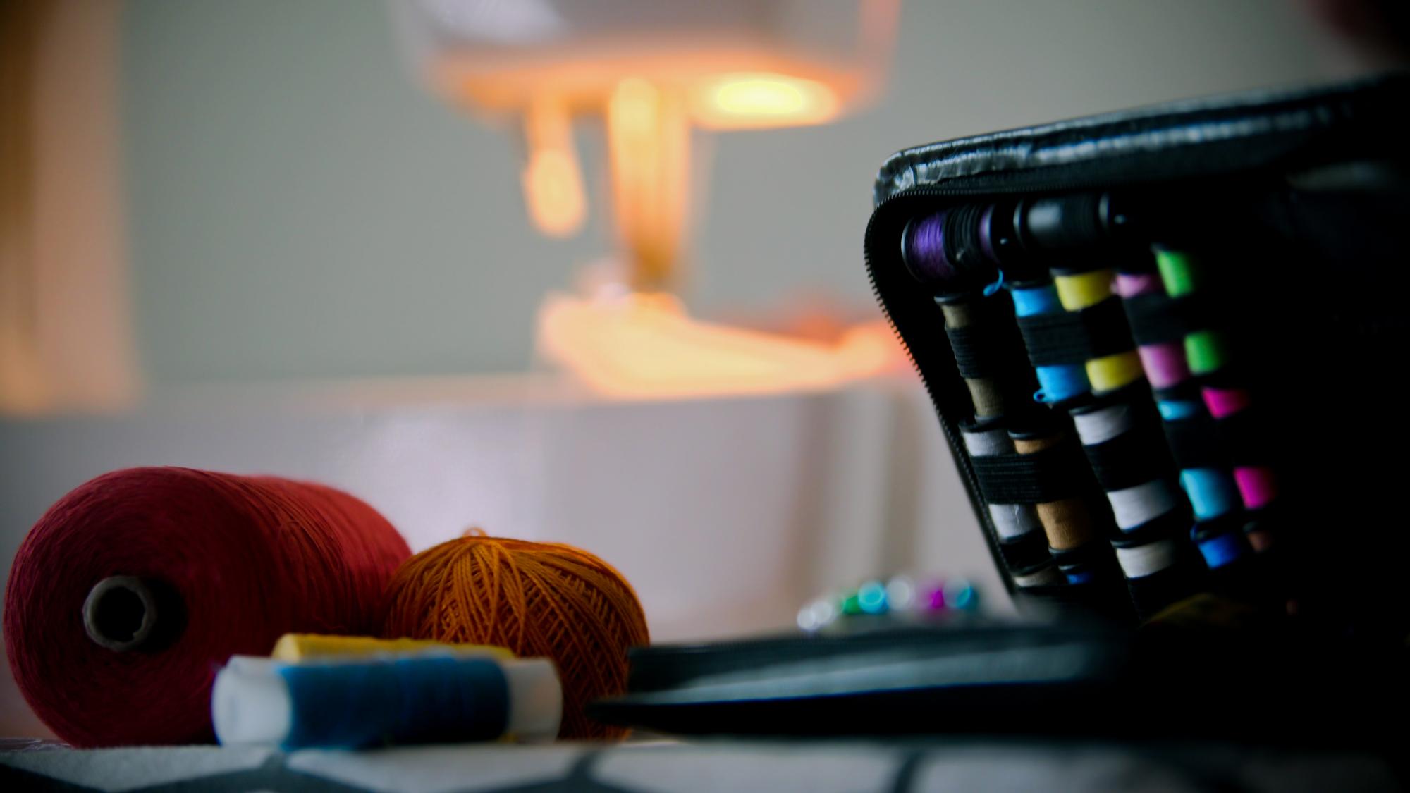 atelier workspace with thread spools and digitizing screen